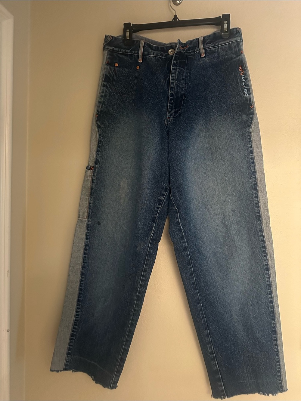Vintage Platinum FUBU baggy jeans with visible orange “Platinum FUBU” branding.